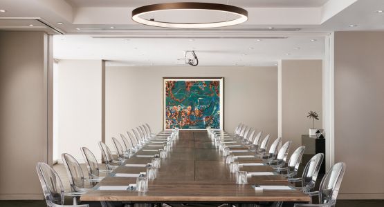 A business hotel space with a long desk and chairs